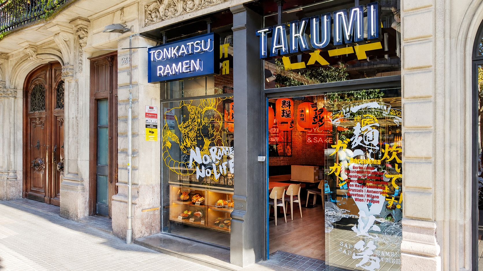 Takumi tonkatsu ramen storefront in Barcelona with a lit food replica display case in the window