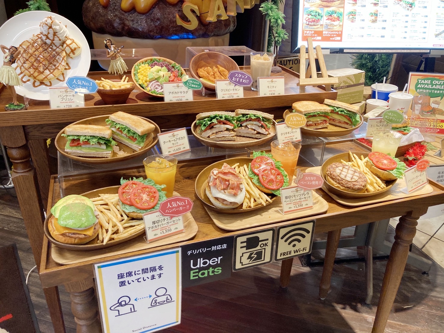 Sandwich, burger and iced drink food replicas paired on a cafe display table
