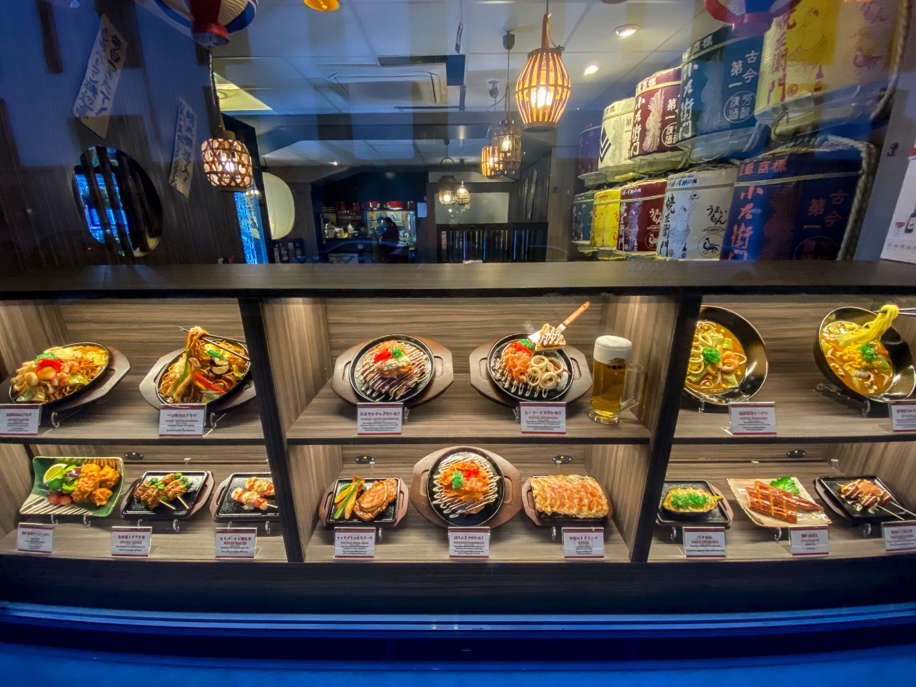 A window display of izakaya food replicas arranged for easy rearranging