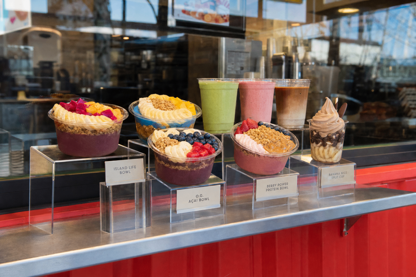Custom food replicas of açaí bowls and smoothies on pedestals at a superfood bar counter